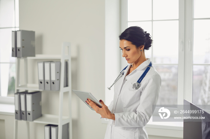 Woman doctor pediatrician standing in the white office of the hospital.