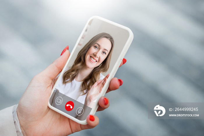 female hand holds a mobile phone in hand and talking to her girlfriend on video chat, video calls, conference