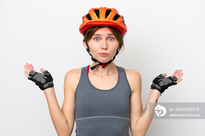 Young cyclist English woman isolated on white background having doubts while raising hands