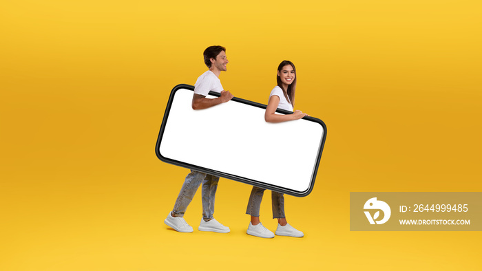 Cheerful couple walking with big white empty smartphone screen