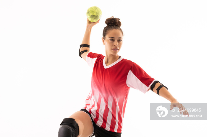 Biracial young female handball player throwing ball while playing against white background
