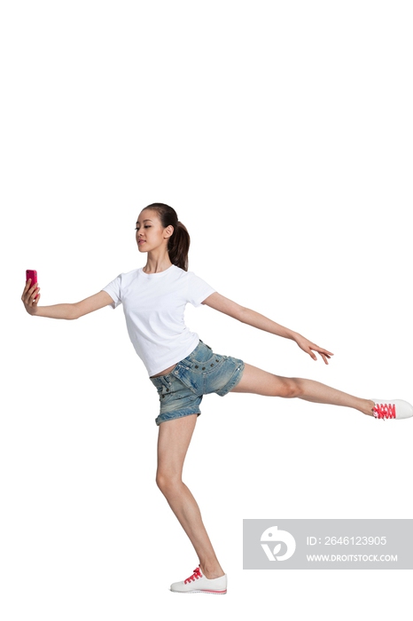 棚拍年轻女人拿着手机跳舞