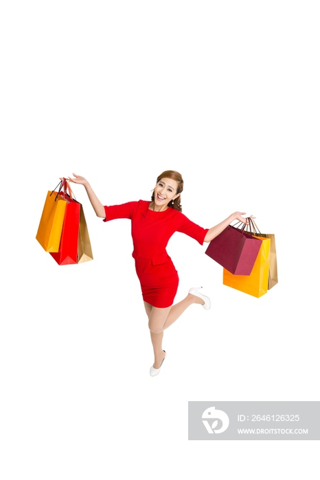 棚拍红裙子的年轻女人提着购物袋