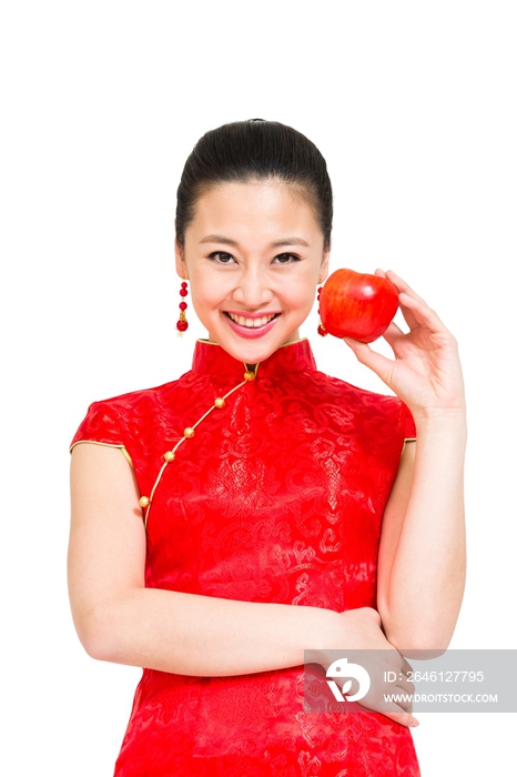 棚拍穿红色旗袍的年轻女人拿着苹果