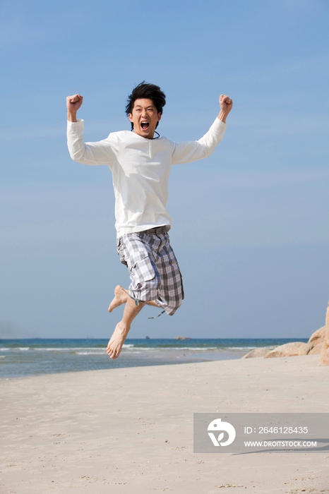 海边休闲装年轻男人跳跃