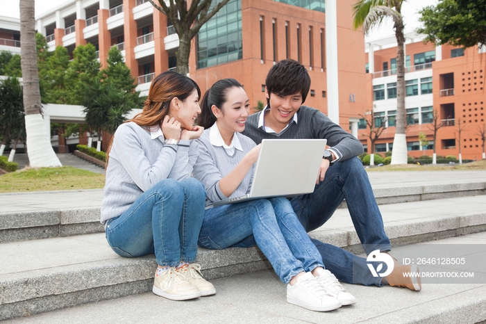 年轻大学生在校园里使用笔记本电脑