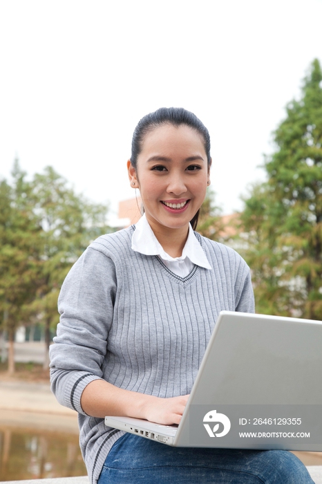 年轻大学生在校园里使用笔记本电脑