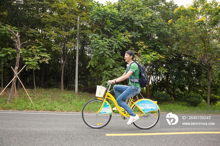 年轻大学生在校园里骑车