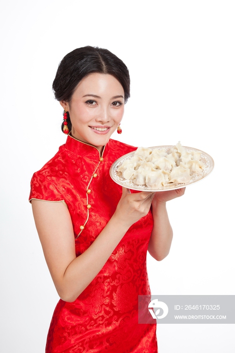 棚拍身穿中国传统服装的年轻女人端饺子