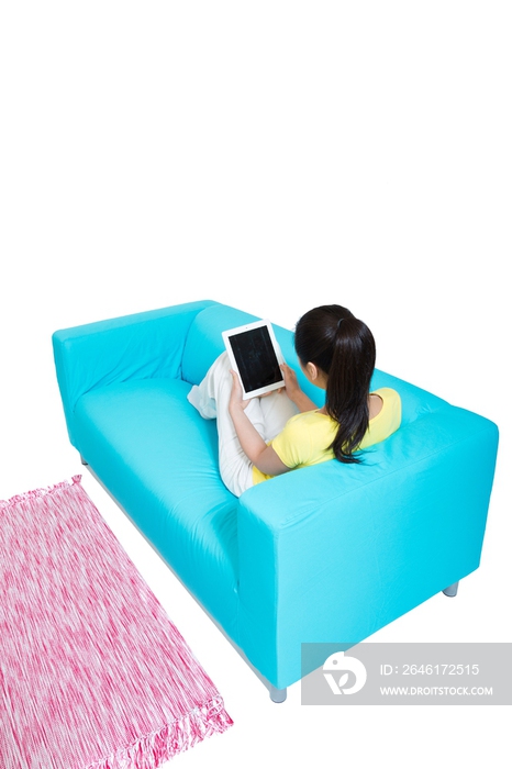 棚拍年轻女人坐在沙发上玩平板电脑