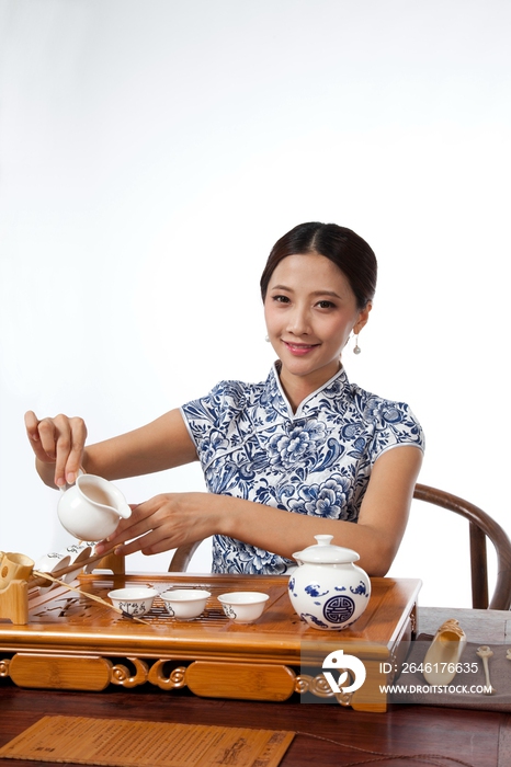 棚拍身穿中国传统服装的年轻女人秀茶艺