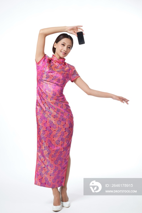 棚拍身穿中国传统服装的年轻女人展示手机