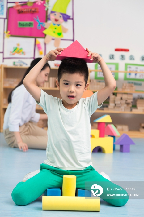 幼儿园儿童坐在地板上玩彩色积木