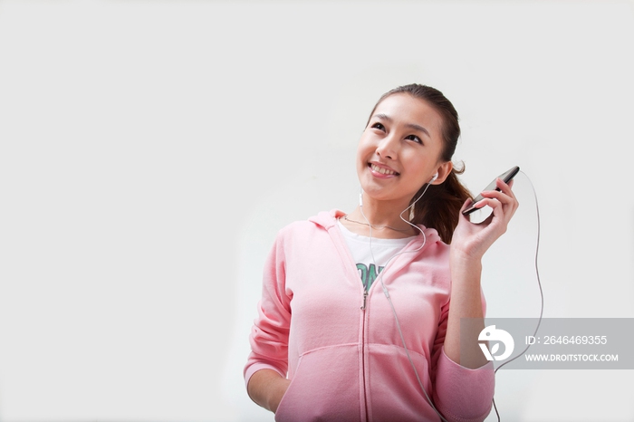 快乐的年轻女人使用手机听音乐