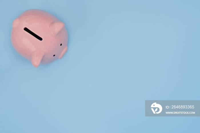 Top view of pink piggy bank for money saving isolated on light blue background with clipping path.