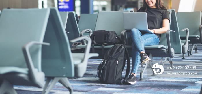 A woman traveler using laptop computer while sitting in the airport