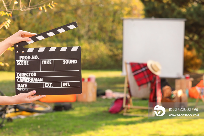 Woman with movie clapper in outdoor cinema