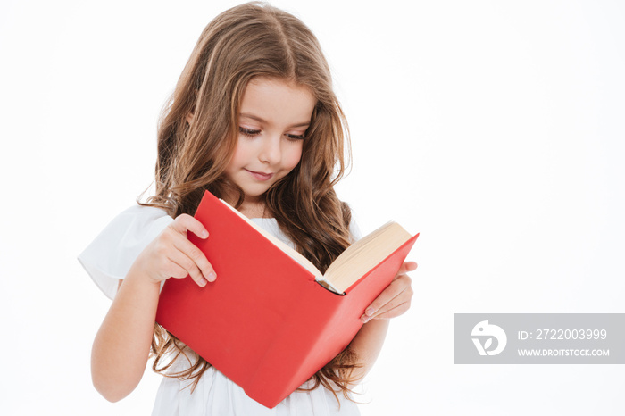 Lovely little girl standing and reading book