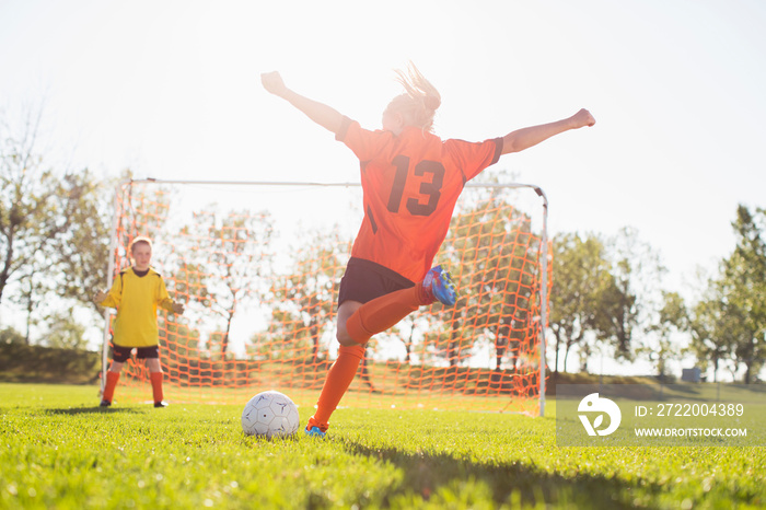 Young female soccer player about to kick soccer ball