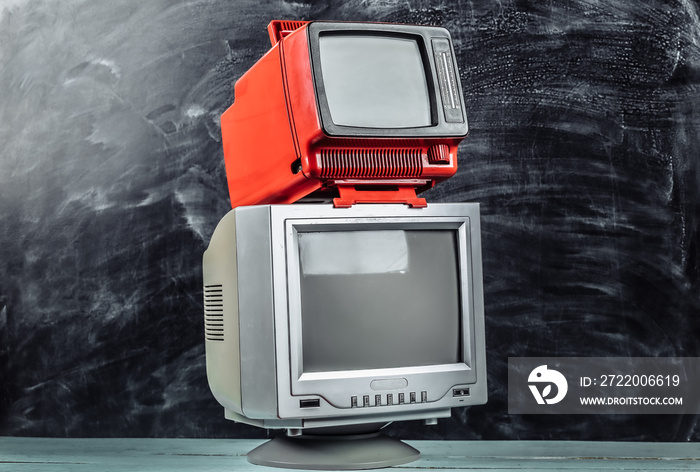 Red retro old school portable mini tvs on blackboard background