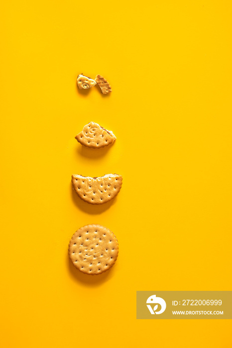 Four stages of Sandwich biscuits cookies  biting on yellow background