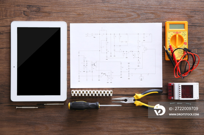 Electrical drawings, tablet and tools on wooden table, top view