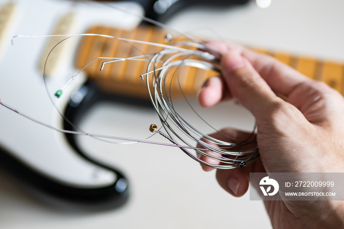 Unwound used guitar strings in guitar technician hand