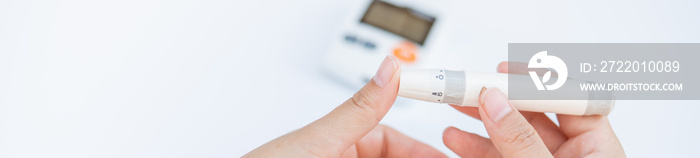 Close up of asian woman hands using lancet on finger to check blood sugar level by Glucose meter, He