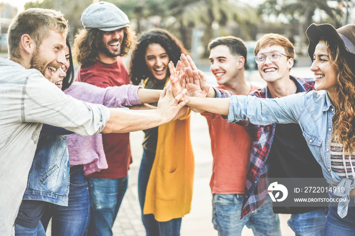 Young millennials friends stacking hands together