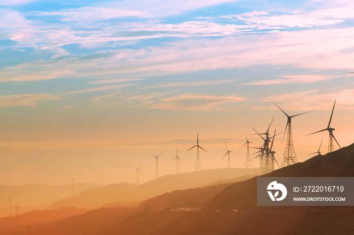 日落时的风力涡轮机，背景是安达卢西亚的山丘、大西洋和非洲的山脉