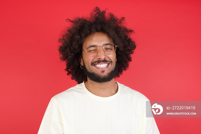 Cute young blond male  wearing White T-Shirt blinking his eyes with pleasure having happy expression