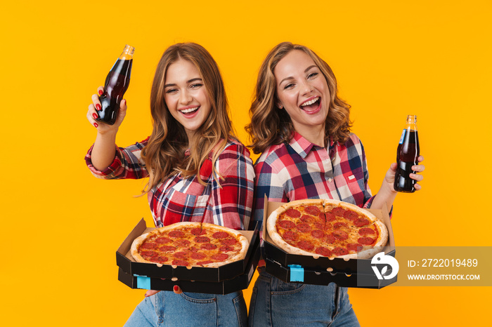两个年轻漂亮女孩拿着披萨盒和苏打水瓶的照片