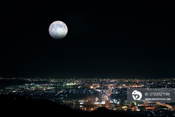 満月が夜景の彼方から姿を見せる