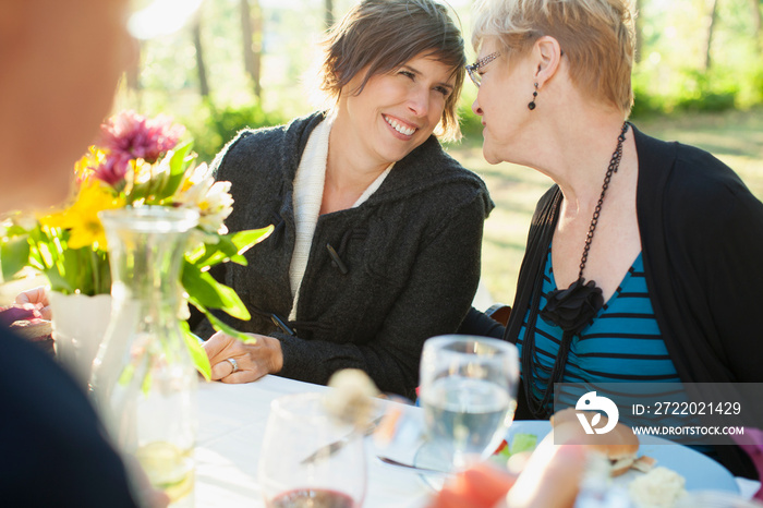 Mother and daughter looking at each other at family dinner