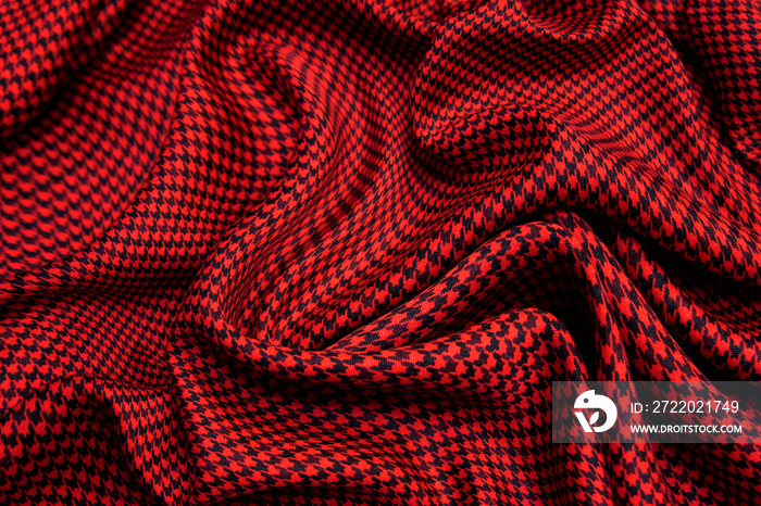 Red and black checkhered gled plaid textile background. Top view.