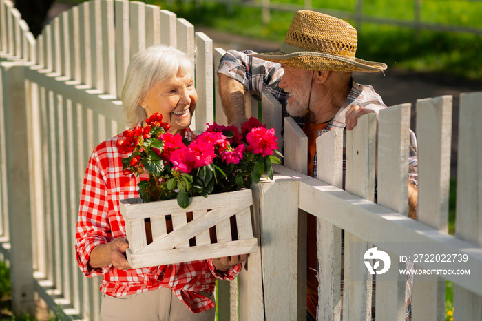 Cheerful retired man and woman living in one neighborhood speaking