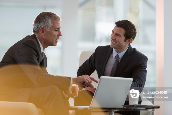 Corporate businessmen talking at laptop