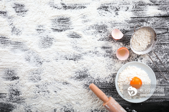 flour and ingredients on black table. Top view