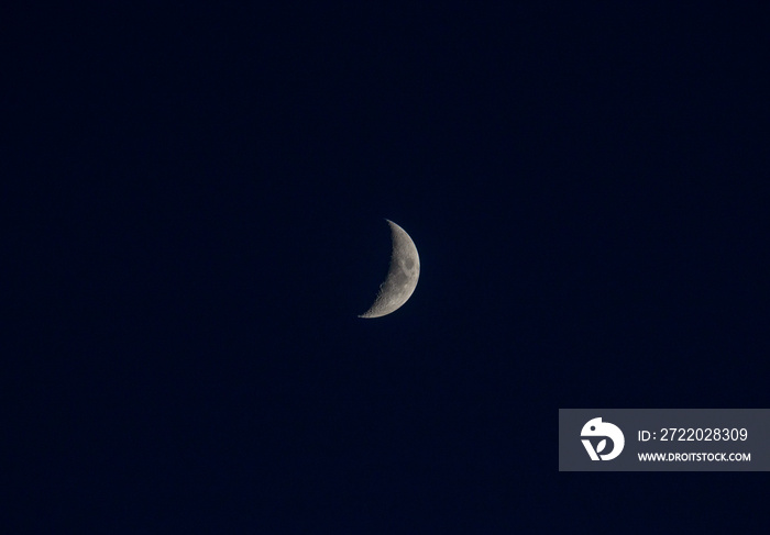 Nice young half moon on dark blue sky at evening