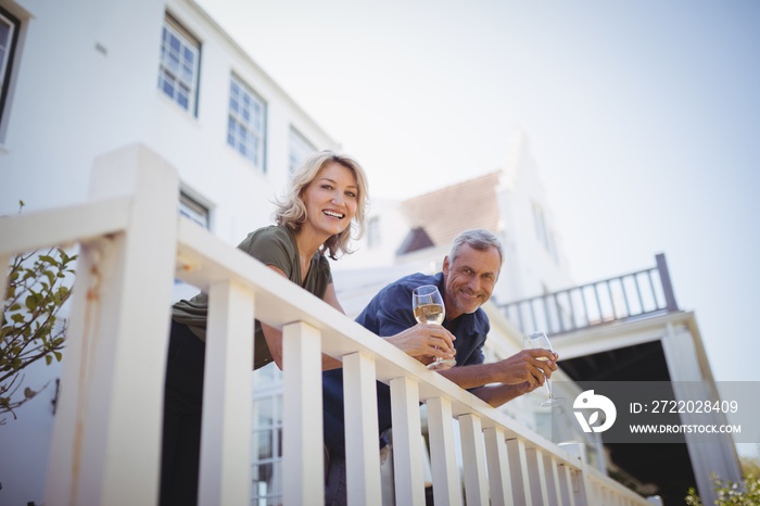 Portrait of mature couple having glasses of wine in balcony