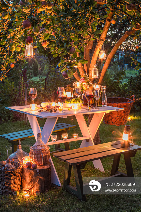 黄昏花园里摆着酒和蜡烛的桌子