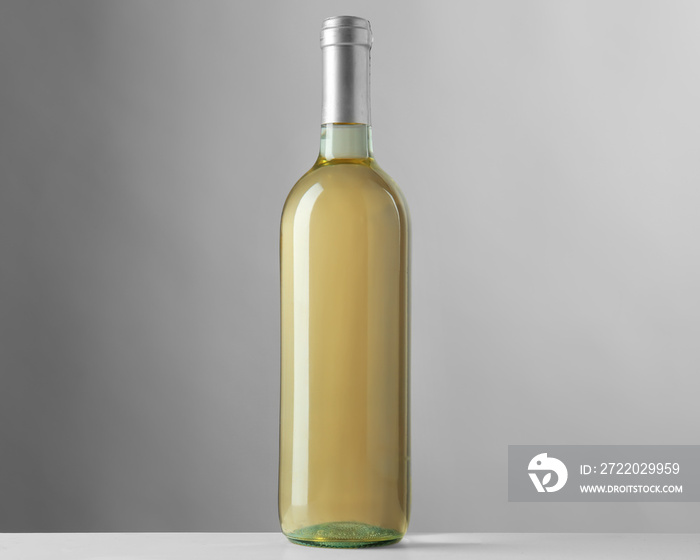 Bottle of white wine on grey background