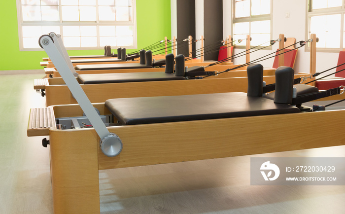 明亮工作室里的普拉提木材改革者系列。健身房锻炼，锻炼设备概念