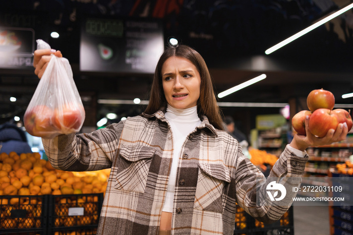 环保女性在超市买苹果。女性杂货店购物者反对使用塑料