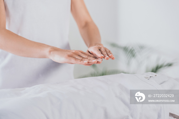 partial view of reiki therapist practising palm healing session