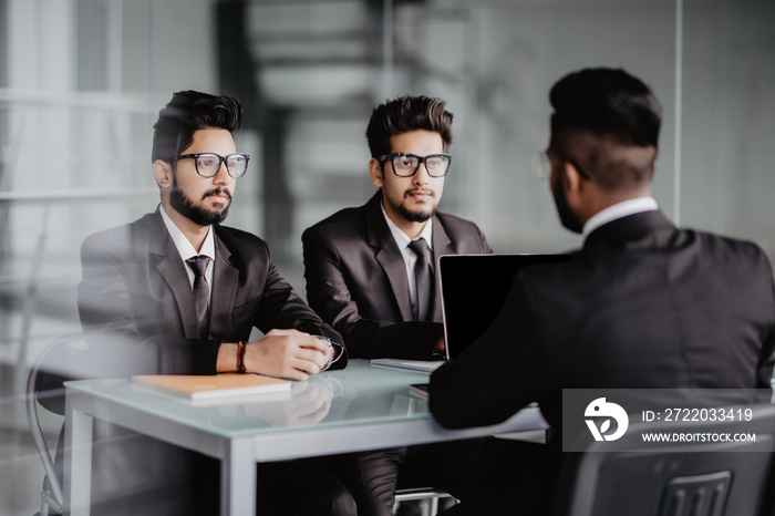 Business meeting. Young indian three businessmen working at office discuss new contract details