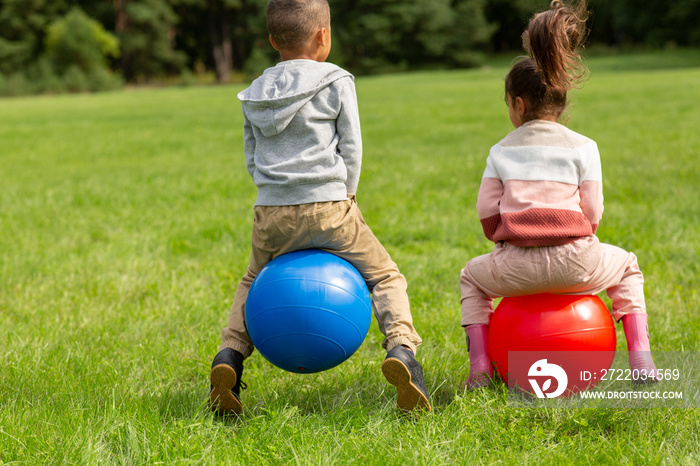 童年、休闲和人的概念——快乐的小男孩和小女孩在跳跃或弹力球上弹跳