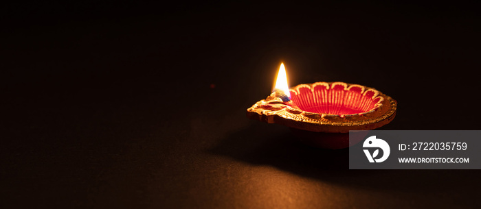 Diwali, Hindu festival of lights celebration. Diya oil lamp against dark background,