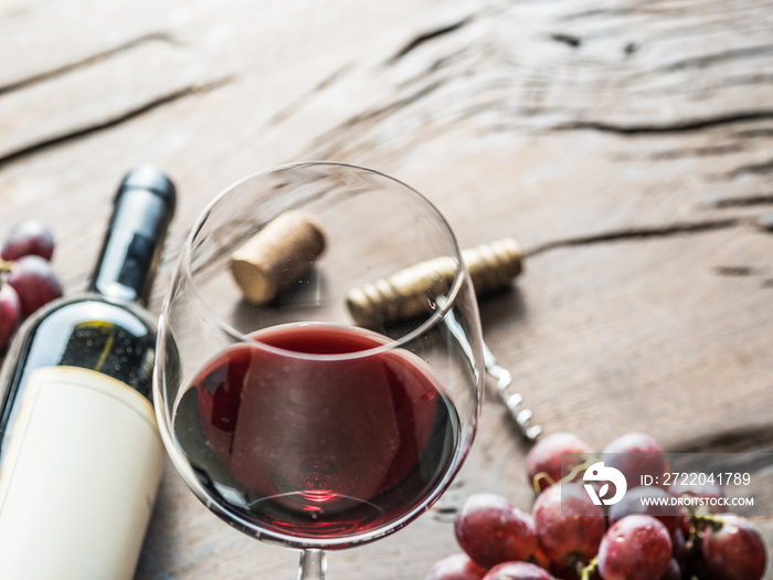 木制背景的酒杯、酒瓶和葡萄。品酒。