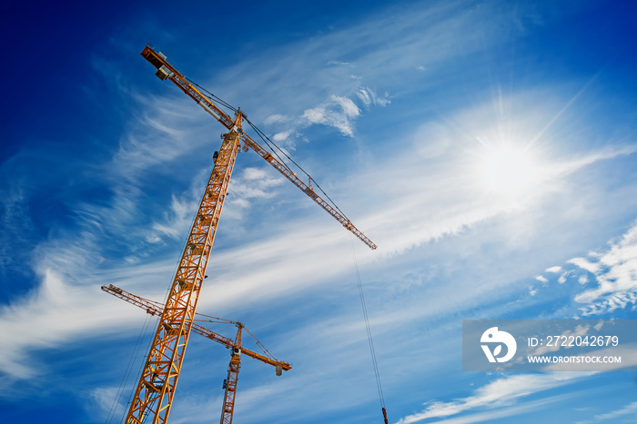 Two Industrial Cranes Working on Construction Site